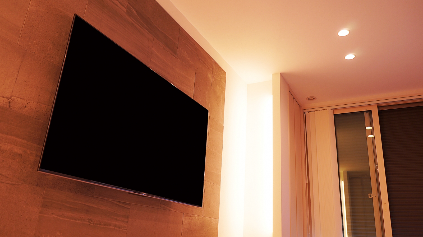 今回は、テレビ設置用に考えられたビルトインスペースにソニー・ブラビアの65インチ「KJ-65X9500G」を壁掛け施工させていただきました。

広々とした空間には、オーナー様ご自身で手掛けられたエコカラット「ストーングレース」が美しく仕上げられています。
壁掛けテレビ用の壁補強や専用コンセントをエコカラット貼り付け後に施工する事で、オーナー様もエコカラットを壁に施しやすかったとお話ししてくださいました。

施工当日に壁内をお調べしたところ壁の補強下地は部分的に入っていましたので、位置決めをしっかりと行いテレビ用コンセントを新設させていただき、ラック内の既存コンセントより周辺機器を露出しない設置ができることで、テレビだけが宙に浮いている理想的な仕上がりを実現できております。

オーナー様からリビング空間をとてもこだわったとお話しいただき、壁掛けテレビの高級感溢れる雰囲気がマッチした事と相まって大変喜んでいただけました。

弊社ではエコカラットの貼り付けと壁掛けテレビの同時施工も承っております。
エコカラット貼り付け前より壁補強をさせていただく事で、エコカラットに補強用の開口跡を残さない綺麗な仕上がりにもこだわらせていただいております。
同時施工を約1日でご対応できる事もオーナー様にとって大きなメリットと考えております。

壁掛け診断フォームよりご相談ください。
https://www.cato.co.jp/wall_tv/entry_upload.php