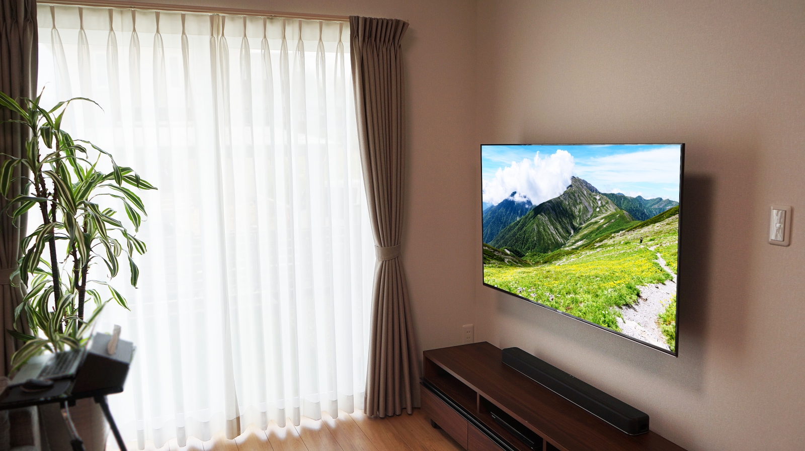 リビングにソニー・ブラビア「KJ-55X9500G」を上下左右可動式金具を用いて壁掛け施工させていただきました。

オーナー様は壁掛けテレビにしたいと思ったキッカケに、テレビの買い替えに加えてテレビ角度を自由にレイアウトできる事に大きなメリットを感じたとお話されていました。

キッチン・ダイニング・リビングからテレビ画面の視認性と見た目をとても重視されて、オプションの上下左右可動式金具をご選択されました。
オプション金具では、壁と金具の設置箇所に化粧カバーが付いておりますので、テレビを引き出した際の見た目にも高級感を醸し出します。
金具を収めた際には正面よりソファーでゆったりと、金具を左右に可動すれば食事中や奥様のキッチン仕事の際も最適な角度で見る事ができますので、多く選ばれる金具タイプになります。

設置後の使用イメージからテレビの高さもじっくりとコンサルさせていただきました。

初めにイメージされていた自由度の高いレイアウトの実現と、壁内配線による周辺機器の接続ケーブルがスッキリした事にも大変喜んでいただけました。