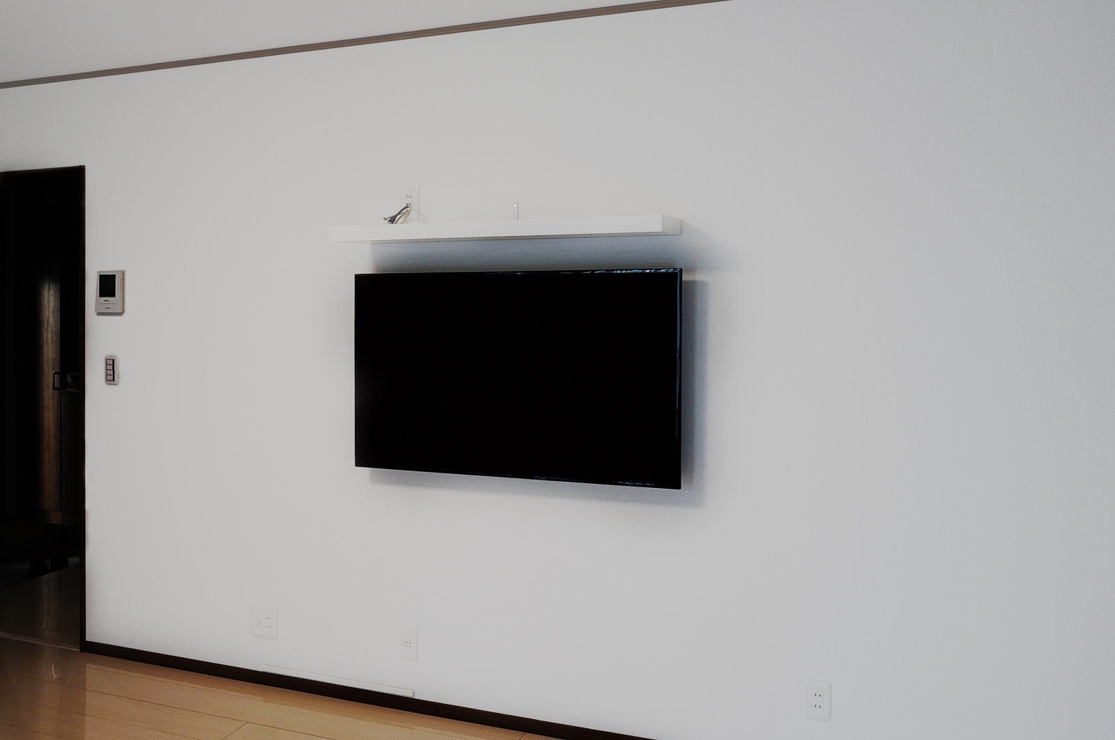 壁幅4m以上の広々とした壁との一体感で絵画感を演出する仕上がりです。幅の長いシェルフで周辺機器設置もシンプルに。