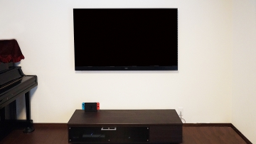 2019年最新モデルであるPanasonic・VIERAの4K有機ELテレビ「TH-65GZ2000」を壁掛け施工させていただきました。

初めは、テレビスタンドでテレビや周辺機器を設置されていましたが、接続ケーブルも多くなるとテレビスタンドでは完全に隠すことは難しいので、見た目の事を意識されて壁掛けテレビ施工のご依頼をされたとお伺い致しました。

またテレビスタンドにて65インチテレビの設置では耐震面において不安なことも、壁掛けテレビにするきっかけになったそうです。

高さのイメージもしっかりとコンサルさせていただき、お部屋の環境から壁掛け位置を決めさせていただきました。
65インチの大画面が宙に浮き、ケーブル露出も無くすことで、イメージされた以上のスタイリッシュな仕上がりにオーナー様には大変満足していただけました。
ご相談から施工完了までの速さにも喜んでいただけました。