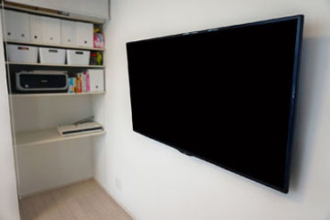 収納棚に専用コンセントを新設し、ブルーレイレコーダー専用の棚へ早変わりです。テレビの壁掛けに合わせてテレビ台も無くしてスッキリとした印象に仕上がりました。