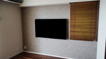 マンションの補強されていないアクセントクロスの壁にソニー・ブラビアの55インチ有機ELテレビ「KJ-55A8F」を壁掛け施工させていただきました。

オーナー様は壁掛けテレビと併せてブルーレイレコーダー用のシェルフ(棚)の取付も構想されておられましたが、録画および視聴頻度があまり高くない事とテレビのみの壁掛けが理想的なカッコよさという事もありまして、シェルフは辞められました。

ポータブルタイプの外付けHDDをテレビ裏に接続・設置することで録画問題は解決し、テレビ裏で完全に隠すことができるので、スッキリとした見た目で番組録画を求められるなら最良な選択肢と言えます。

壁内は配線するには十分なスペースがあり、対角の既存コンセントまではケーブルを一切露出することなくご対応させていただきました。

向かって左下のコンセントには、HDMI専用端子と電源コンセントを1系統ずつ備えていますので、ブルーレイレコーダーやゲーム機を繋ぎたいときにも対応できる環境になっております。

HDMIの専用端子の為、使わないときにもすっきりとした印象に仕上がります。

ケーブルも一切見えずに、テレビがまるで絵画のように薄く壁掛けされた雰囲気に、オーナー様には大変喜んでいただけました。