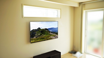 小窓や掃き出し窓から差し込む日差しがとても暖かい印象のリビングにPanasonic・VIERA(ビエラ)55インチ有機ELテレビ「TH-55GZ1000」を壁掛け施工させて頂きました。

オーナー様からは、「お部屋をスッキリとさせたい」「子供がテレビを触っても転倒しないように」という点から壁掛けテレビにしたいと考えられたそうです。
新築に合わせて壁掛けテレビにしたいという事もご用命されたキッカケになったと仰っておられました。

オーナー様は補強の事も含めて、興味津々に施工過程をご覧になっておられました。
壁補強・ジャストップ工法の仕組みや、壁内状況を一緒になって確認及びご説明しながらの進行にも大変ご安心されている印象をお受け致しました。

薄型のテレビモデルという事もあり、壁との一体感と合わせて宙に浮いた存在感にご夫婦で大変喜んで頂く事ができました。

thumbnail.php?id=123_3.jpg
(↑キッチンから見た壁掛けテレビです。)

対面式キッチンからソファー越しでもゆったりと見られる高さに設置できる事も壁掛けテレビの大きなメリットです。

キッチン仕事をしながらでも楽々視聴できる高さには、奥様にもとても喜んで頂けました。