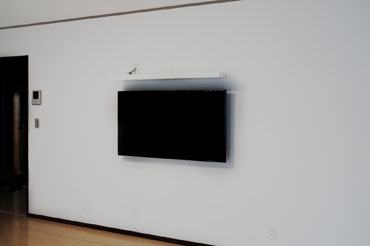 壁幅4m以上の広々とした壁との一体感で絵画感を演出する仕上がりです。幅の長いシェルフで周辺機器設置もシンプルに。