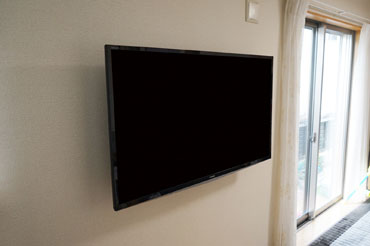 壁掛けテレビとしての設置で、家族みんなのライフスタイルに合わせたポジションを実現することができました。
既存のアンテナ端子から、距離(約3m)があるものの天井裏からの配線作業によって配線が露出することない仕上がりになりました。

録画も外付けHDDをご選択されることで、テレビだけの設置で見た目をスタイリッシュにこだわっております。