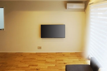 陽が注ぎ込む明るいリビングの一角にテレビを壁掛けしました