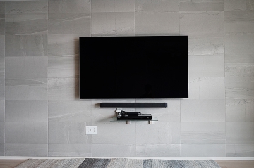 エコカラット「ストーングレース」が施された壁にソニーの有機ELテレビ65インチ「KJ-65A8F」を壁掛けさせていただきました。
エコカラット貼り付け前にジャストップ補強を施させていただき、エコカラット貼り付け後に再度訪問致しまして壁掛け施工をさせていただきました。(計2回訪問です。)
事前に補強工事をさせていただける事で、エコカラットへの開口跡もなくなり補強されていない壁でも後付け感のない美しい仕上がりになるのが魅力です。

オーナー様はさらにこだわられてサウンドバーの壁掛けとブルーレイレコーダー用シェルフの壁掛け施工も合わせてご用命いただけました。

全てをエコカラット施工の前から準備することで、エコカラットへの傷も無く美しく仕上げさせていただきました。

見た目、迫力、使い勝手においてオーナー様には大変喜んでいただけました。

弊社でエコカラットと壁掛けテレビの同時施工をご用命の際には1回のご訪問で同様な施工イメージを最短即日でご対応させていただいております。