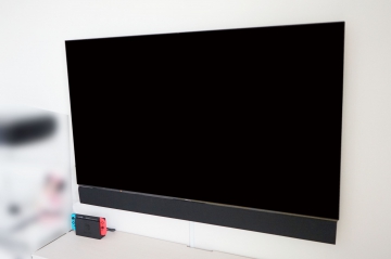 三重県鈴鹿市のマンションでコンクリートにクロスが貼られた壁にPanasonic・VIERAの65インチ有機ELテレビ「TH-65FZ1000」を壁掛けさせていただきました。
コンクリート壁の場合には、アンカー打設によって壁掛け金具を固定させていただきます。

壁の中に配線スペースは無いため、ケーブル配線はモール(配線カバー)でテレビ台からテレビ裏へ配線させていただきました。
オーナー様は事前に壁状況を管理会社様にご確認されていましたので、施工前より施工イメージをしっかりコンサルさせていただけました。

壁掛けさせていただきましたテレビは本体下部に専用スピーカーを固定するモデルでしたので、モールも目立たない仕上がりにオーナー様にも大変喜んでいただけました。